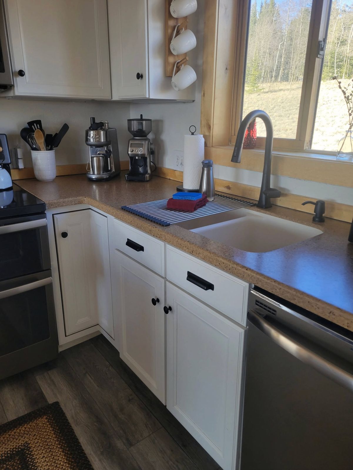 Spotless cabin kitchen with coffee bar and forest window view