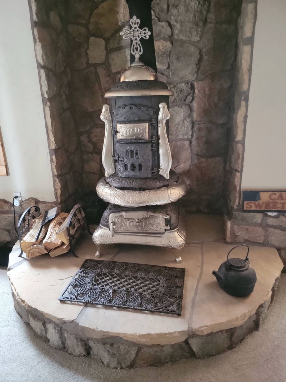 Antique Round Oak wood stove on stone hearth