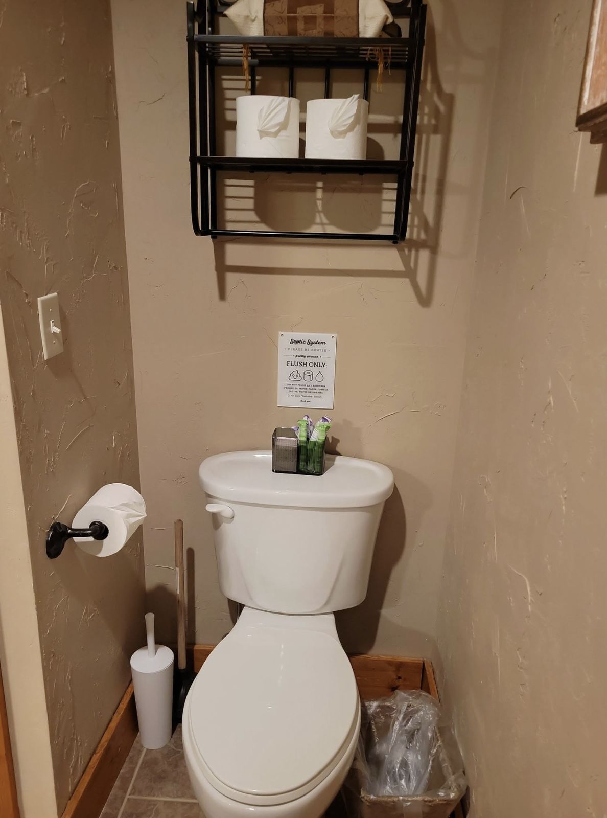 Guest bathroom stocked with paper products and septic-friendly signage